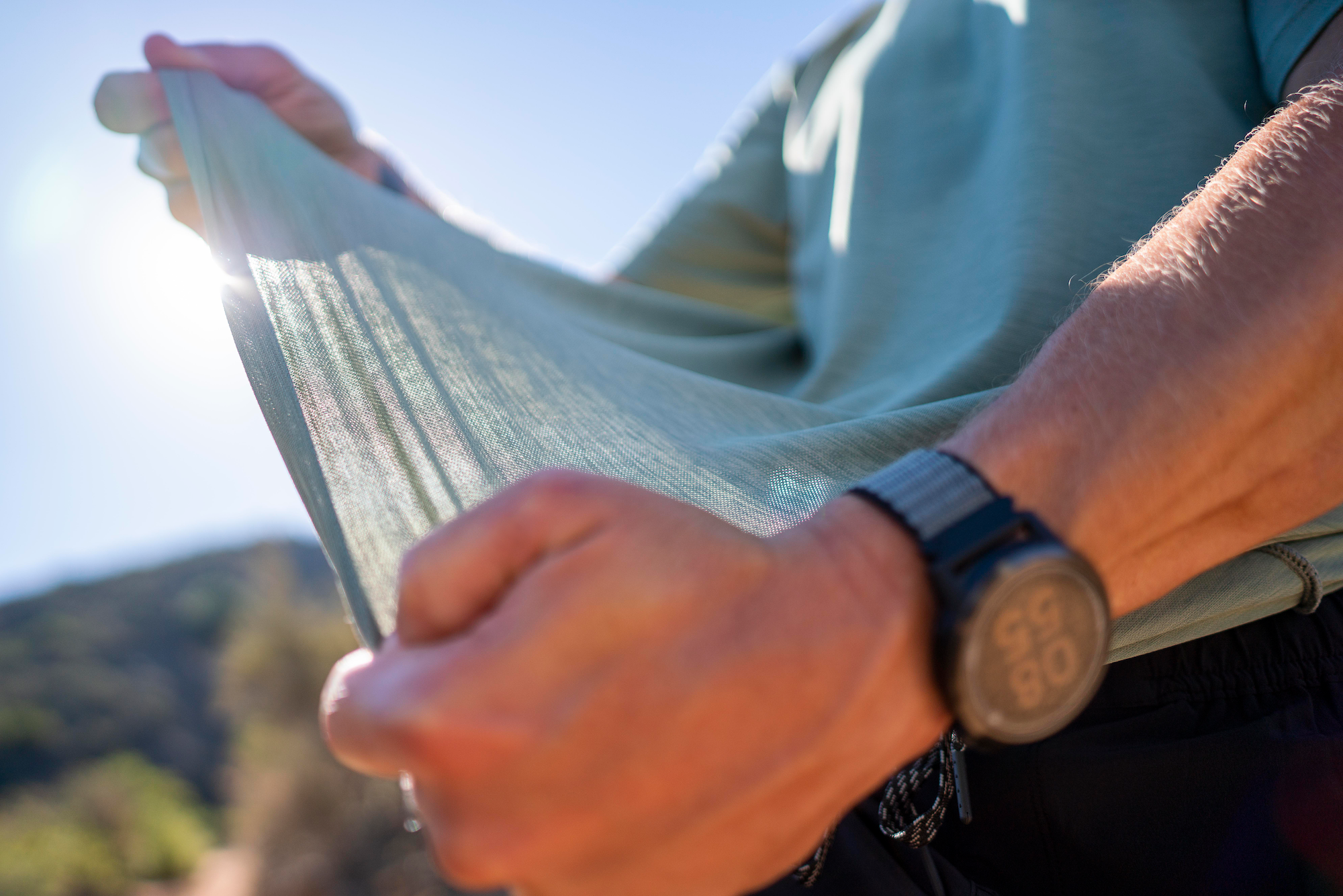 Close-up of Anetik lightweight breathable performance fabric being stretched to show flexibility and comfort outdoors
